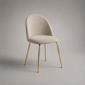 Sedia da pranzo imbottita in tessuto riccio beige con piedini in acciaio dorato e schienale arrotondato, 52 × 58 × 82 cm